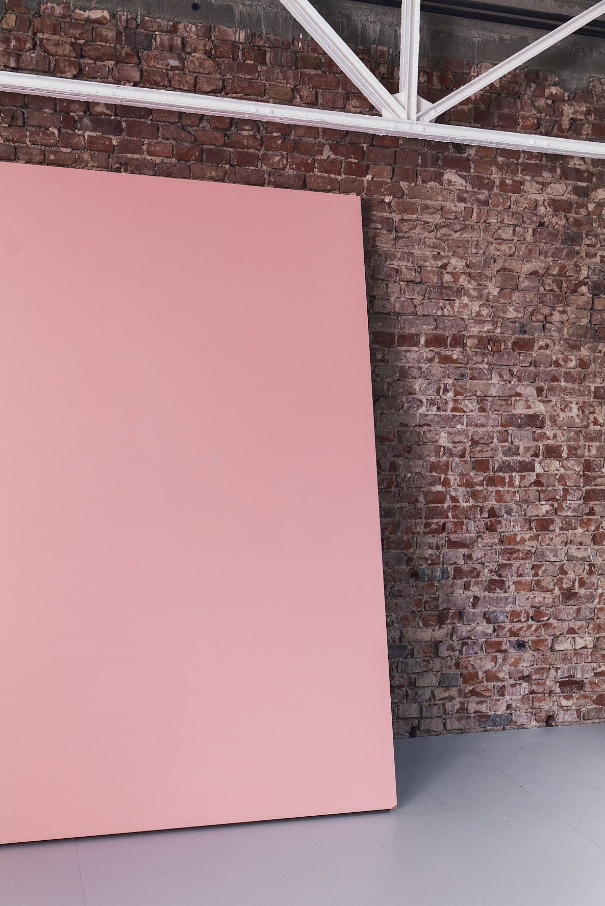 Eine rosa Stellwand lehnt an der Backsteinwand von Werkraum.01